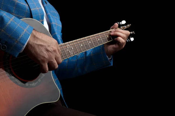 Guitarra acústica na ribalta tocada por um homem — Fotografia de Stock