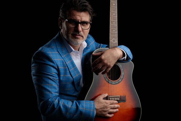business man sitting and holding his guitar happy