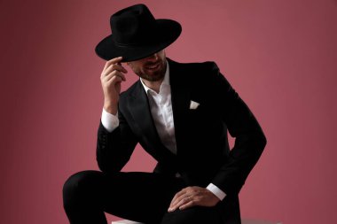 Gizemli dramatik adam bacağına yaslanıyor ve kibarca selamlıyor. 