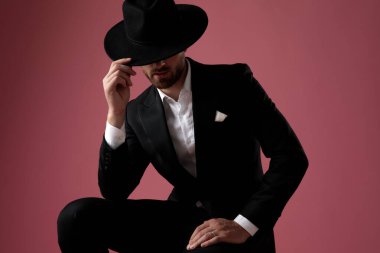 Gizemli görünüşlü damat kibarca selamlıyor ve bacağına yaslanıyor. 