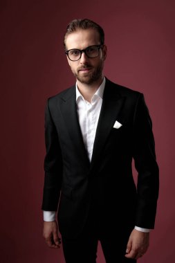 Dramatik zarif adam gözlük takarken ileriye bakıyor. 