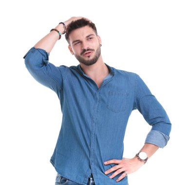 Düşünceli bir adam eli belinde başka yere bakıyor.