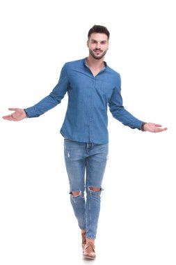 Kolları açık yürüyen yakışıklı sıradan bir adam.