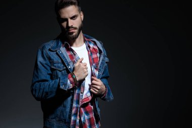 Motivated casual man adjusting his shirt and looking 