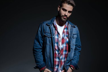 Çekici görünümlü genç adam iki elini de tenceresinde tutuyor.