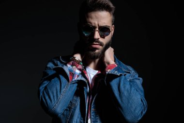 Düşünceli sıradan bir adam iki elini de boynunda tutuyor. 