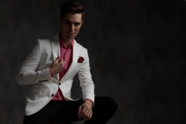 Ceketini düzenleyen kendine güvenen zarif bir adam. 