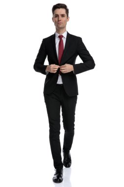 Kendine güvenen iş adamı ceketinin düğmelerini açıyor.