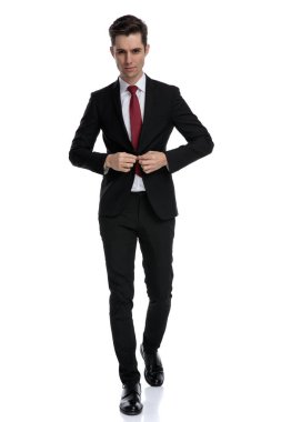 Yakışıklı iş adamı ceketinin düğmelerini açıyor.