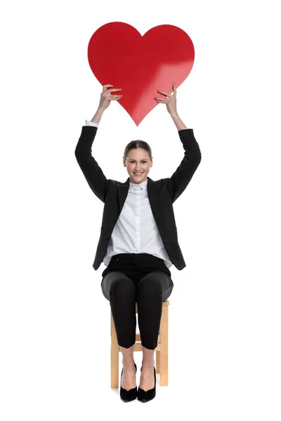 Femme d'affaires tenant un grand coeur rouge au-dessus — Photo