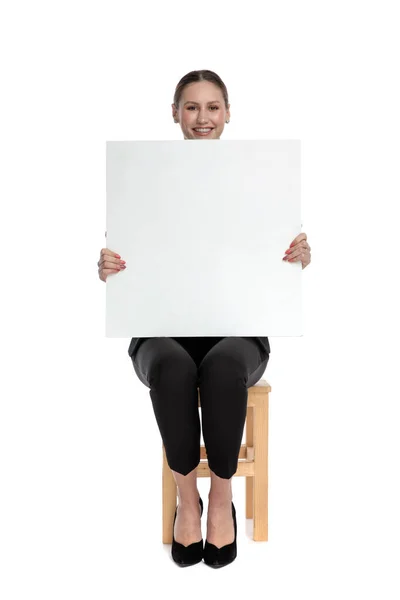 Businesswoman sitting and presenting a blank billboard — स्टॉक फ़ोटो, इमेज