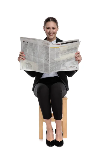 Mujer de negocios sentada y sosteniendo el periódico feliz —  Fotos de Stock