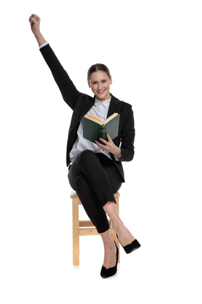 Geschäftsfrau hält ihr Buch in der Hand und eine Faust in die Höhe — Stockfoto