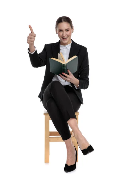Empresária segurando seu livro enquanto fazendo sinal ok — Fotografia de Stock