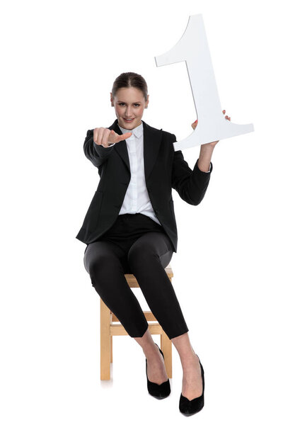 businesswoman presenting number one while pointing forward