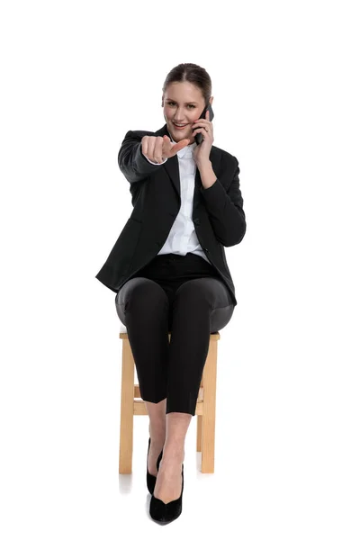 Businesswoman talking on the phone while pointing forward — Stock Photo, Image