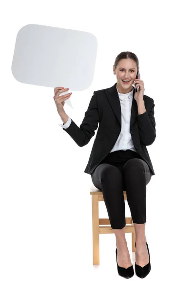 Businesswoman staring at camera with speech bubble and phone — Stock Photo, Image