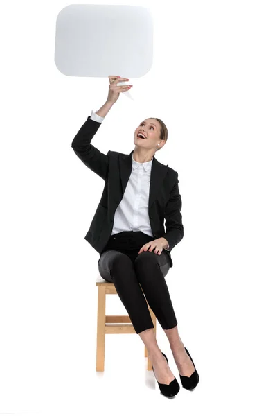 Donna d'affari tenendo e guardando verso l'alto la bolla discorso — Foto Stock