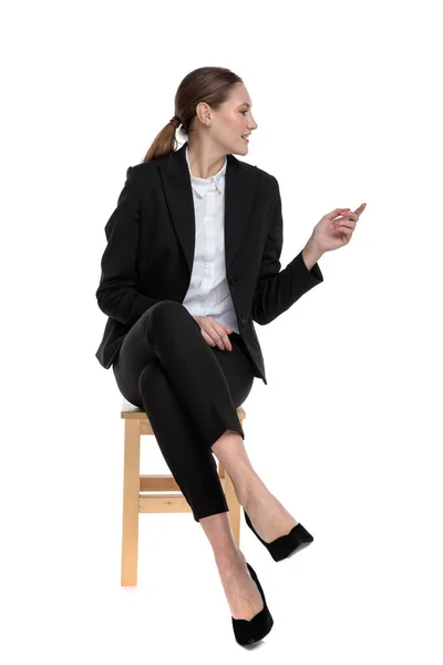 Bizneswoman siedzi i rozmawia z kimś na boku — Zdjęcie stockowe