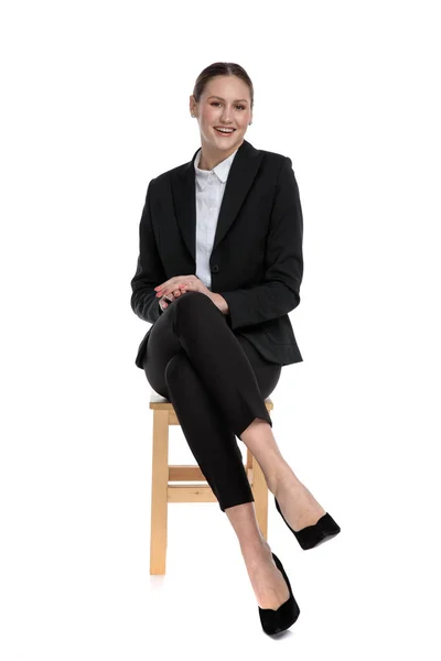 Businesswoman sitting with crossed legs and resting hands — Stock Photo, Image