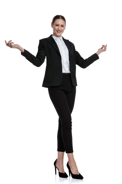 Businesswoman standing with crossed legs and greeting with open — Stock Photo, Image