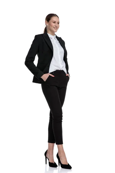 Businesswoman standing with crossed legs and looking ahead — Stock Photo, Image