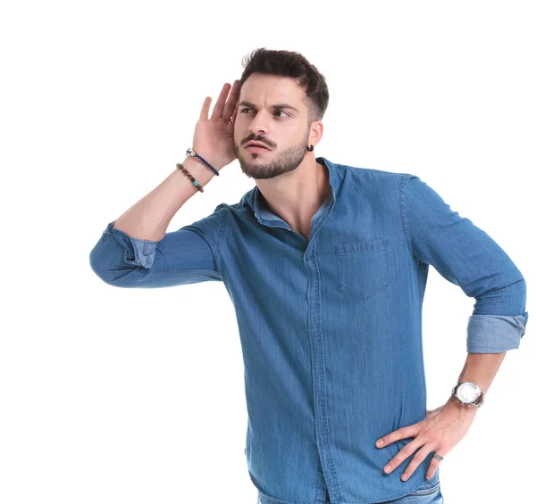 Curious casual man listening with his hand around his ear — Stock Photo, Image