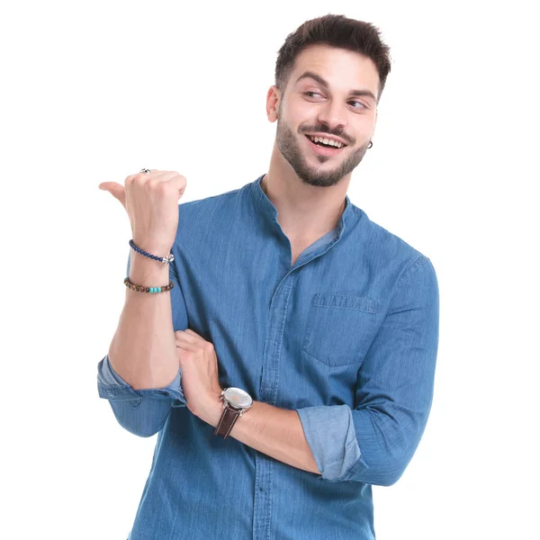 Merry casual man laughing and pointing to the side — Stock Photo, Image