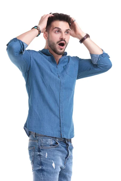 Amazed man looking away with his hands on his head — Stock Photo, Image