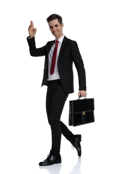 Charming businessman greeting and holding a briefcase — Stock Photo, Image