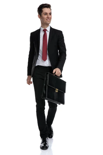 Hopeful businessman holding a briefcase and looking away — Stock Photo, Image