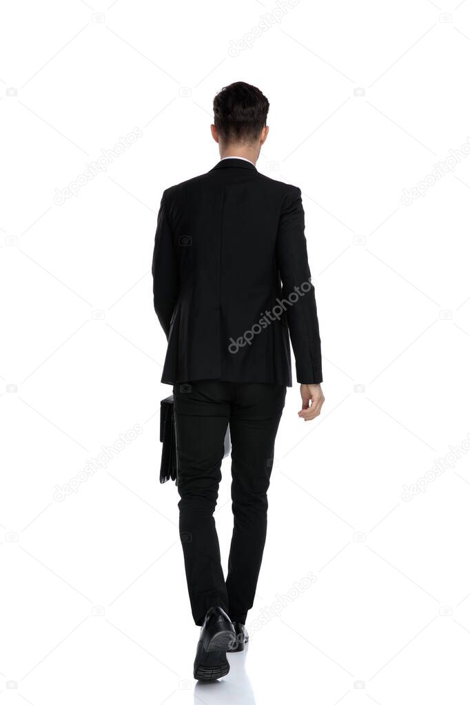 Rear view of a confident businessman holding a briefcase 