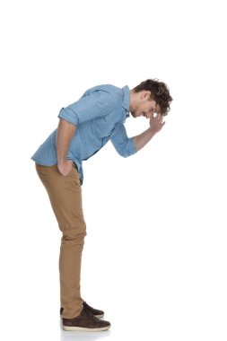 Yan gözle genç bir adamın el ele tutuşması ve aşağı bakması, zor bir şey görmeye çalışması, beyaz arka planda izole edilmiş, tüm vücudu.