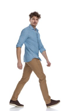 Beyaz arka planda, tüm vücudu izole edilmiş kot gömlekli çekici bir adam.