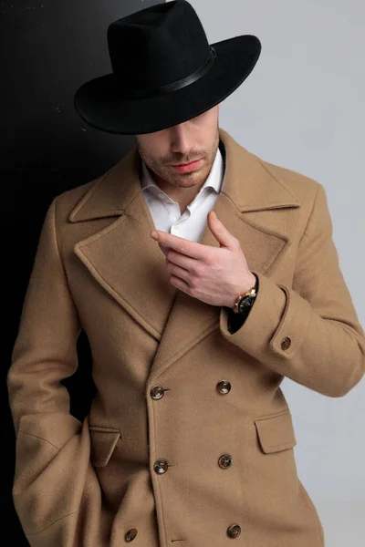 Enigmatic Young Model Long Coat Wearing Hat Pointing Finger Side — Stock Photo, Image