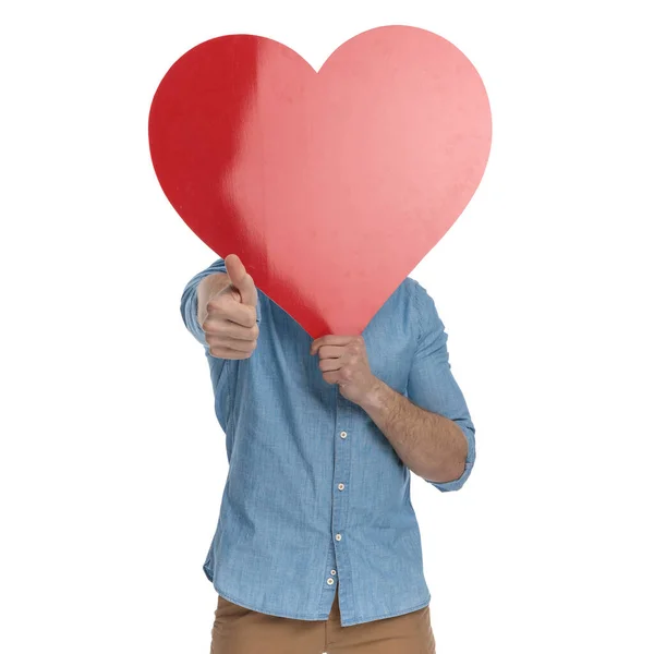 Feliz Joven Cubriendo Cara Con Gran Corazón Rojo Haciendo Pulgares — Foto de Stock