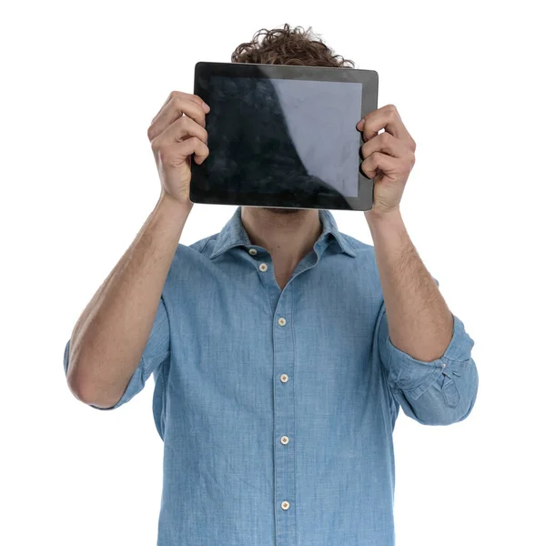 Young Casual Guy Wearing Denim Shirt Hiding Tablet Standing Isolated — Stock Photo, Image