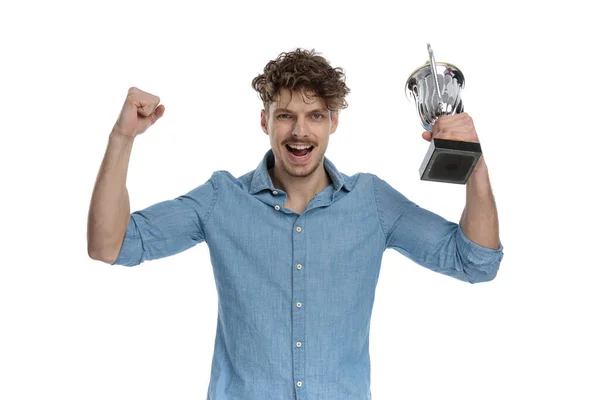 Animado Jovem Casual Cara Celebrando Vitória Segurando Troféu Isolado Fundo — Fotografia de Stock