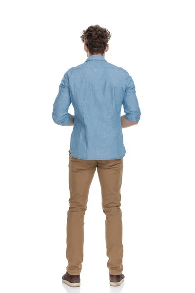 デニムシャツを着て白い背景に孤立した立ち姿の若いカジュアルな男の後ろ姿 — ストック写真
