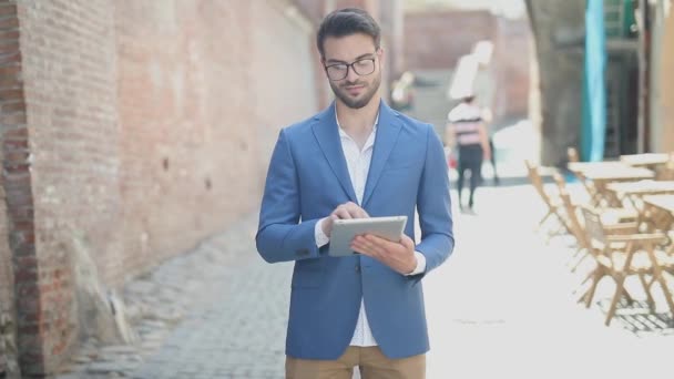 Jonge Gelukkige Zakenman Staat Buurt Van Een Bakstenen Muur Sms — Stockvideo