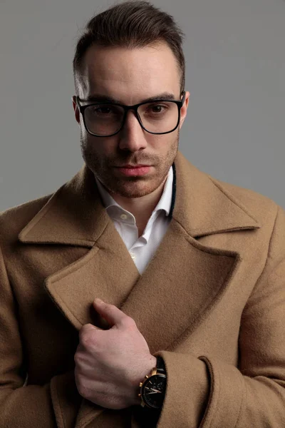 Jovem Empresário Vestindo Óculos Fixando Casaco Longo Fundo Cinza — Fotografia de Stock