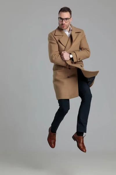 Attrayant Jeune Homme Portant Long Manteau Sautant Sur Fond Gris — Photo