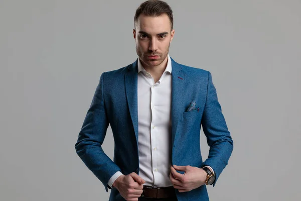 Sexy Young Smartcasual Man Adjusting Blue Coat Standing Grey Background — Stock Photo, Image