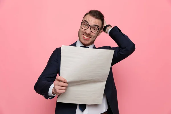 Verwirrter Junger Geschäftsmann Anzug Mit Brille Zeitungslektüre Und Kratzendem Kopf — Stockfoto