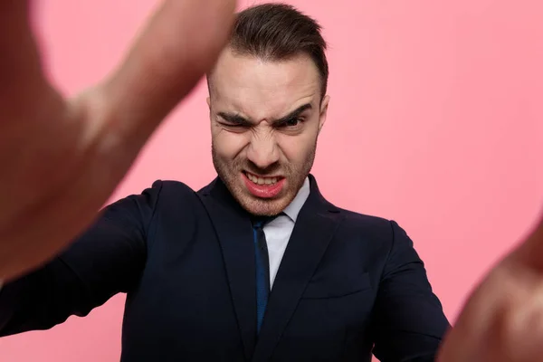 Joven Hombre Negocios Elegante Traje Haciendo Caras Tontas Sosteniendo Enmarcando —  Fotos de Stock