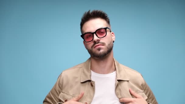 Joven Arrogante Hombre Casual Con Chaqueta Gafas Sol Ajustando Chaqueta — Vídeo de stock