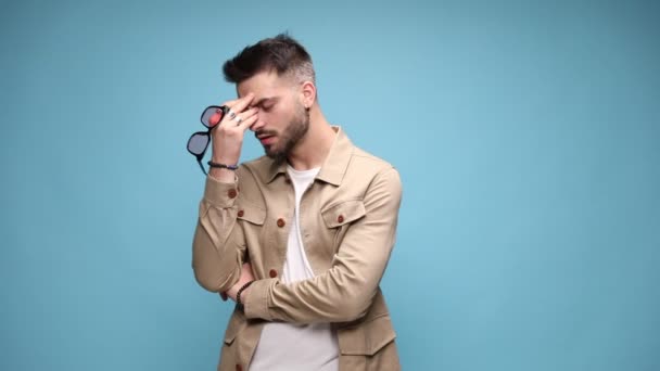 Jeune Homme Réfléchi Veste Tenant Des Lunettes Soleil Massant Front — Video