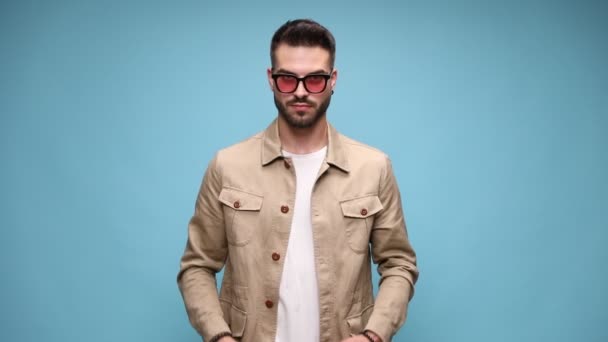 Pewny Siebie Młody Mężczyzna Noszący Okulary Poruszający Się Układający Kurtkę — Wideo stockowe