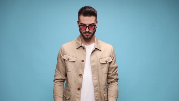 Pemuda Santai Mengenakan Jaket Dan Kacamata Hitam Melihat Bawah Dan — Stok Video