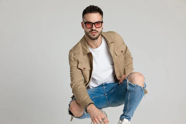 Sexy Young Casual Man Jacket Wearing Sunglasses Holding Elbow Knee — Stock Photo, Image